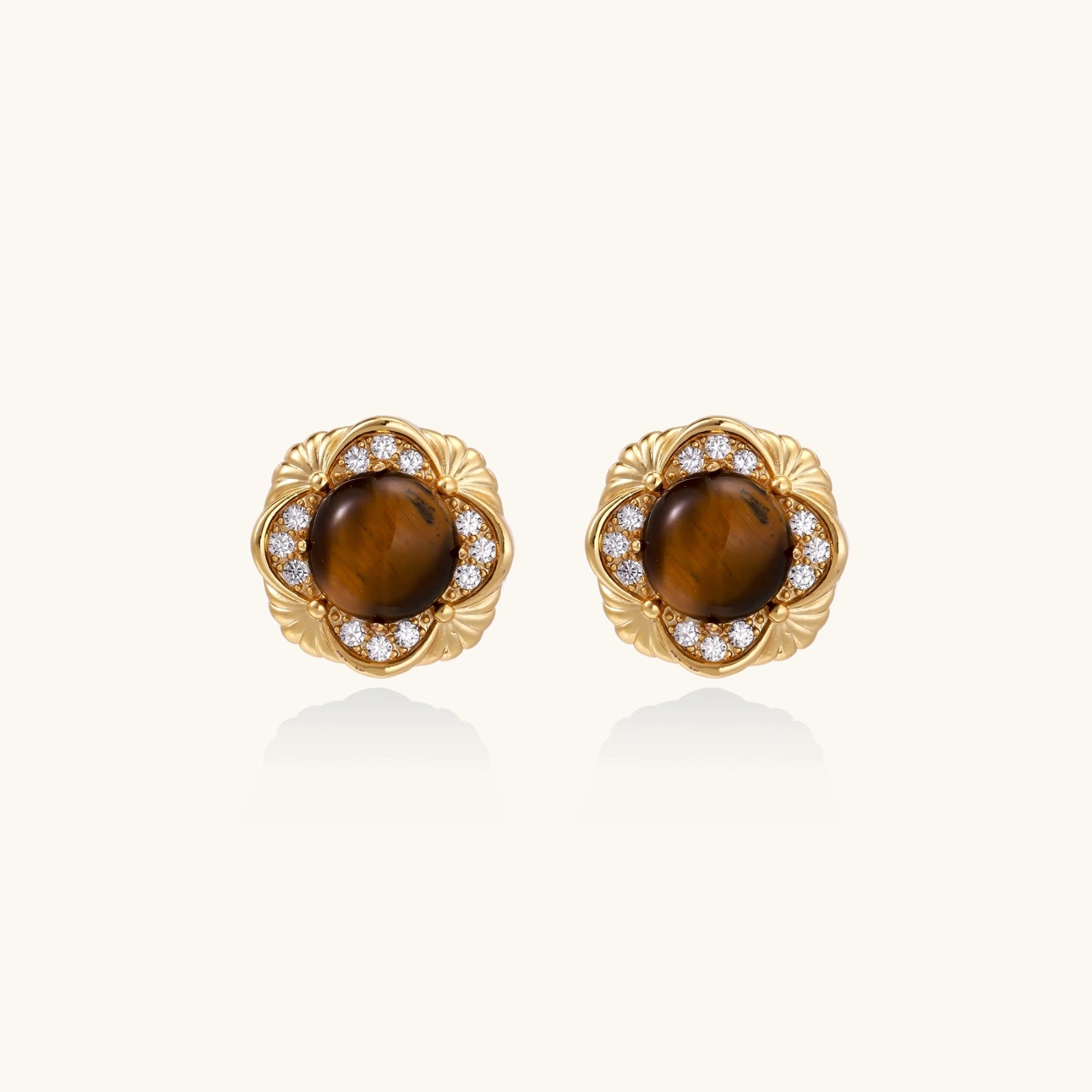 Gold-plated stud earrings with ornate floral frames surrounding cabochon tiger's eye stones and zirconia accents
