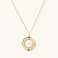 Gold pendant necklace with circular orbital design, iridescent mother-of-pearl center, and green zirconia accents