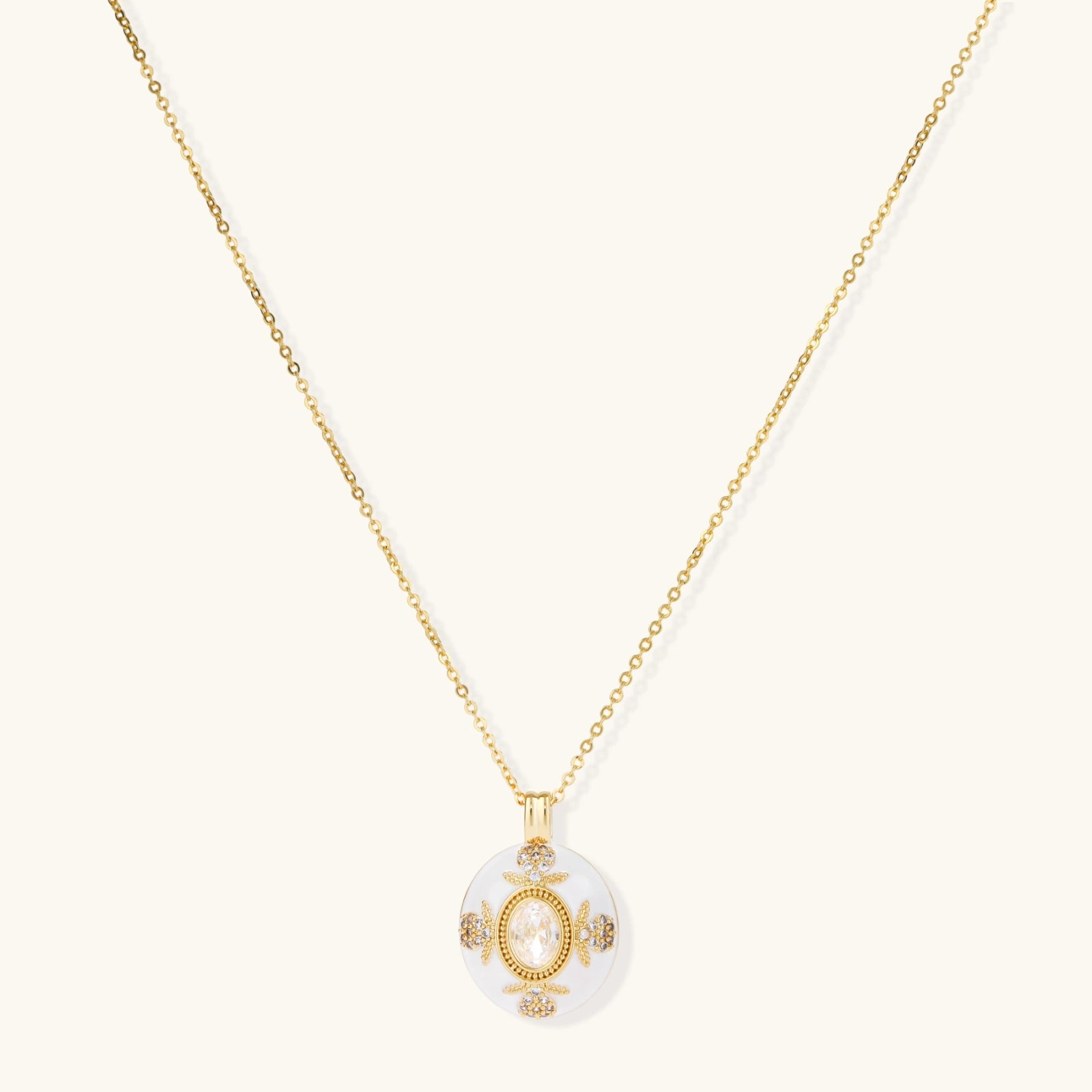 Gold-plated necklace with circular white enamel pendant featuring central zirconia stone and ornate decorative details