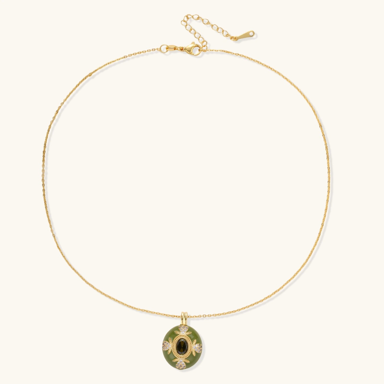 Gold-plated pendant necklace with green enamel background and oval olive cubic zirconia center stone with crystal accents.